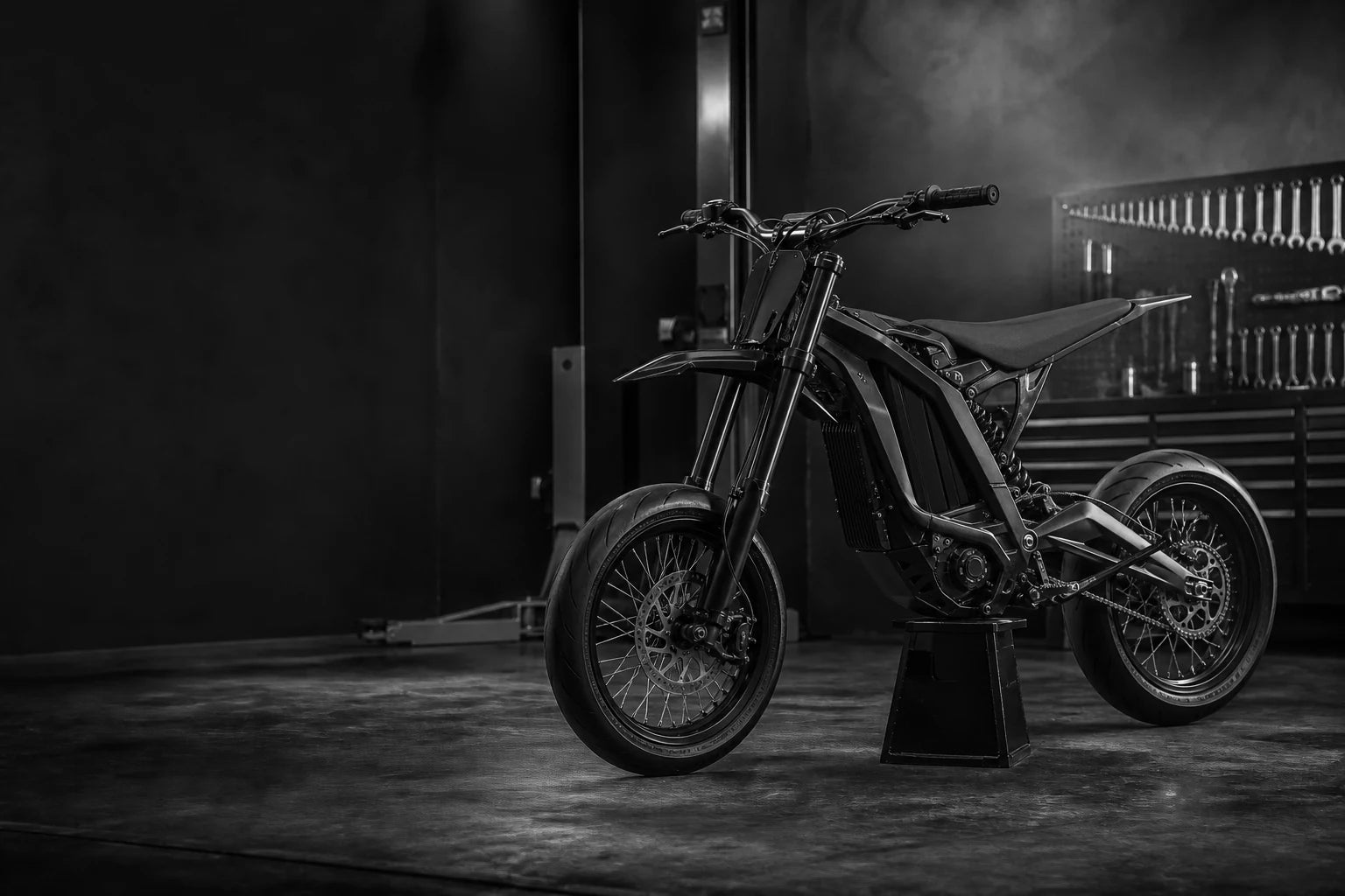 Surron Light Bee X-style supermoto build in a monochrome performance workshop